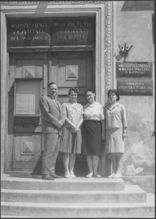 [Dyrektor Władysław Malewski z pracownikami biblioteki na tle gł&oacute;wnego wejścia do Wojew&oacute;dzkiej i Miejskiej Biblioteki Publicznej w Białymstoku]