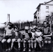 Dzieci siedzące na płocie w ogrodzie pana Dryla, ul. Starobojarska, około 1955 r.