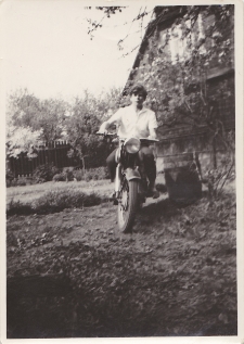 Mężczyzna na motocyklu w ogrodzie, ul. Majowa 14, Białystok, lata 60-70. XX w.