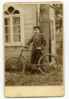 Mężczyzna w mundurze służbowym z rowerem, zdjęcie wykonane w atelier fotograficznym, Białystok, przełom XIX i XX w.