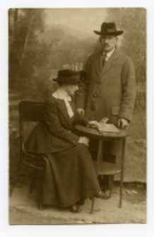 Mężczyzna i kobieta przy stoliku, zdjęcie wykonane w atelier fotograficznym, Białystok, przełom XIX i XX w. Fot. Atelier fotograficzne "APOLLO"