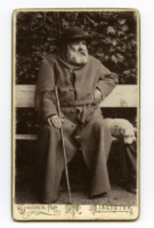 Starszy mężczyzna z psem, zdjęcie wykonano w atelier fotograficznym, ul. Sienkiewicza 18, Białystok, 1888-1915 r. Fot. Bracia Budryk