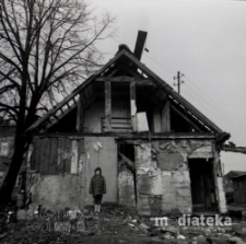 Portret dziewczynki na tle budynku z drewna, okolice ul. Młynowej, Białystok, druga połowa lat 70. XX w., fot. ze zbiorów Andrzeja Trzcińskiego