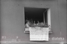 Kobieta wyglądająca z okna podczas procesji Bożego Ciała, ul. Lipowa, Białystok, druga połowa lat 70. XX w., fot. ze zbiorów Andrzej Trzcińskiego