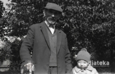 Dziecko z dziadkiem w ogrodzie, Bielsk Podlaski, druga połowa lat 70. XX w., fot. ze zbior&oacute;w Andrzeja Trzcińskiego