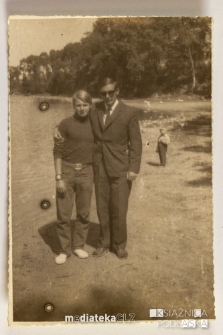Dwóch mężczyzn w przyjacielskim uścisku na tle jeziora, PGR Kociołek, 1973 r.