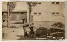 Chłopak pompujący ręcznie wodę, w tle podwórko, PGR Kociołek, 1973 r.
