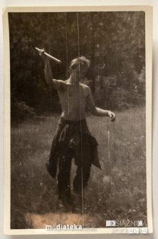 Chłopak unoszący w powietrzu narzędzie pracy