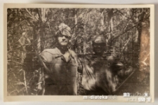 Dwóch mężczyzn pozujących z narzędziami wśród drzew