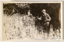 Dwóch mężczyzn wrzucających na stertę ścięte krzaki