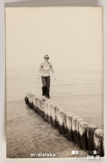 Chłopak chodzący po drewnianych palach na brzegu morza, Ustka, 1979 r.