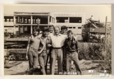 Portret zbiorowy nastoletnich chłopców z opiekunem, na tle szkieletu powstającego budynku