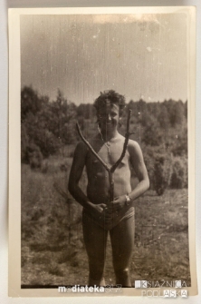 Młody, uśmiechnięty chłopak pokazujący znalezisko