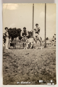 Młodzi mężczyźni prężący muskuły na kąpielisku