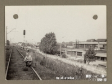 Chłopak siedzący na torach kolejowych