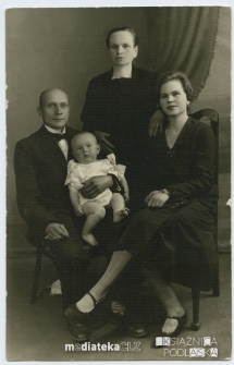 Rodzinne zdjęcie, siedzą: Waleria Janina Bogdanowicz z domu Pancerzyńska, Józef Bogdanowicz, na rękach trzyma Ignacego Bogdanowicza, nad nimi stoi Aleksandra Pancerzyńska (matka Walerii Janiny Bogdanowicz)