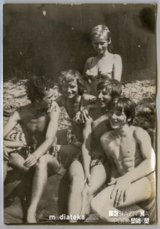 Grupa młodych ludzi opalająca się na plaży