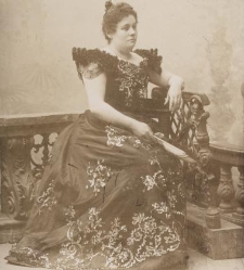 Elwira Wieczorek siedząca w długiej sukni z wachlarzem w ręku