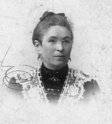 Portret kobiety w średnim wieku, na ramionach koronki, włosy zaczesane do góry wstążka na czubku głowy