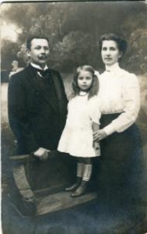 Kobieta i mężczyzna z dziewczynką w białej sukience