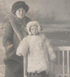 Zdjęcie młodej kobiety z dzieckiem ubranych w zimowe ubrania zrobione w atelier fotograficznym