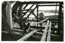 Młoda kobieta na rusztowaniach odbudowywanego kościoła nad Wigrami