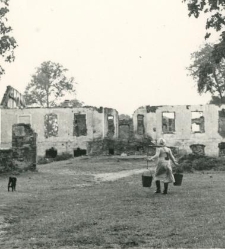 Kobieta niosąca wiadra na tle ruin dworu