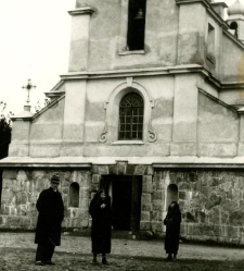 Dwie kobiety i mężczyzna na tle kościoła