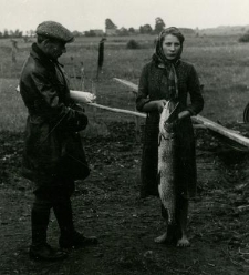 Kobieta trzymająca złowioną rybę i mężczyzna