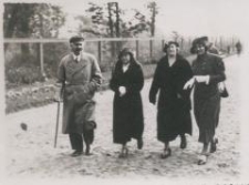 Trzy kobiety i mężczyzna idą przez park