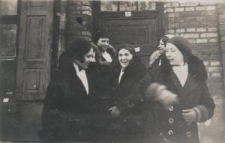 Grupa dziewcząt przed murowanym budynkiem