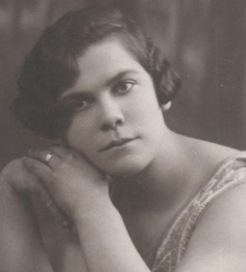 Portret kobiety w letniej sukience opartej o blat